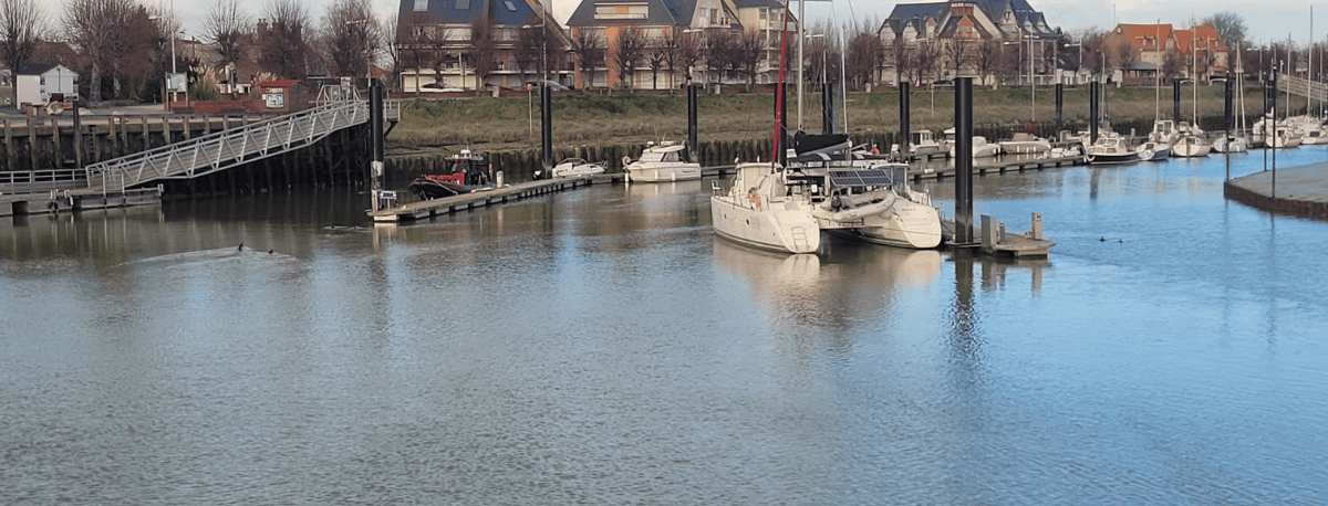 Port de plaisance du Crotoy avec voiliers amarrés et reflets sur l’eau calme.