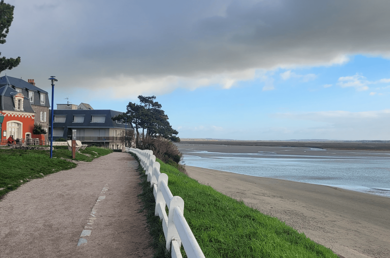 Promenade en bord de mer du Crotoy, digue piétonne et maisons face à la baie.