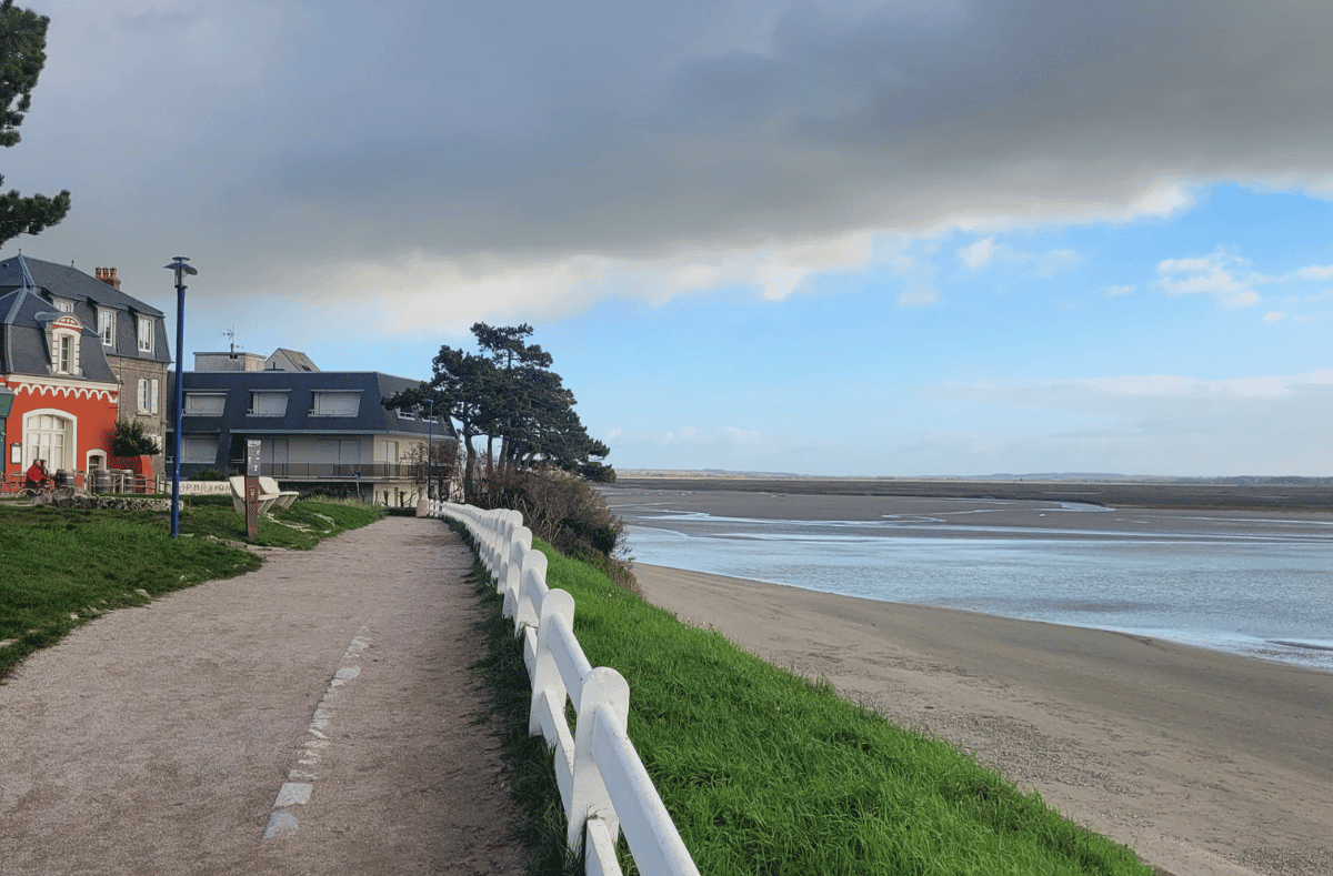 Promenade en bord de mer du Crotoy, digue piétonne et maisons face à la baie.
